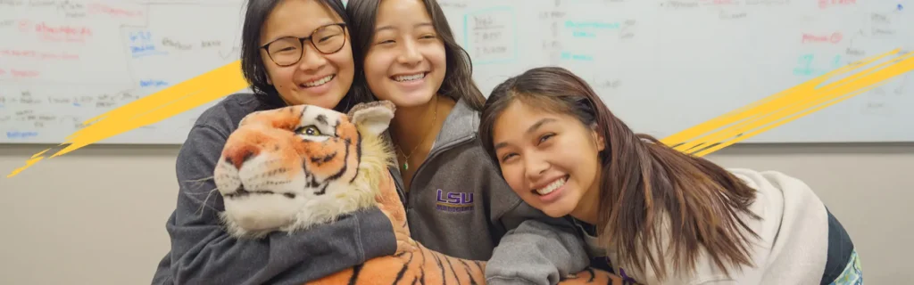 LSU Health students hugging a stuffed tiger mascot
